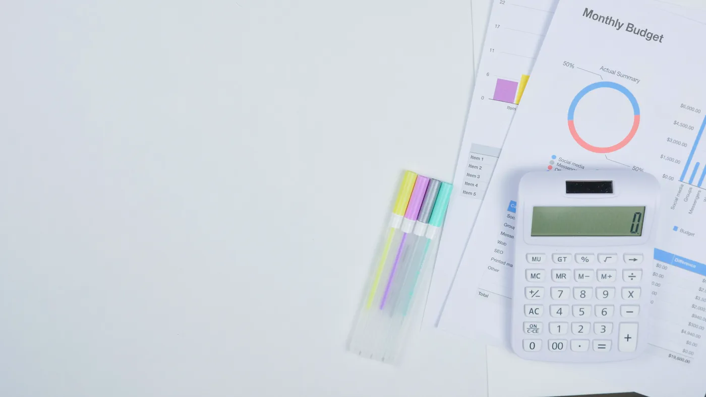 Calculator and monthly budget worksheets on a desk