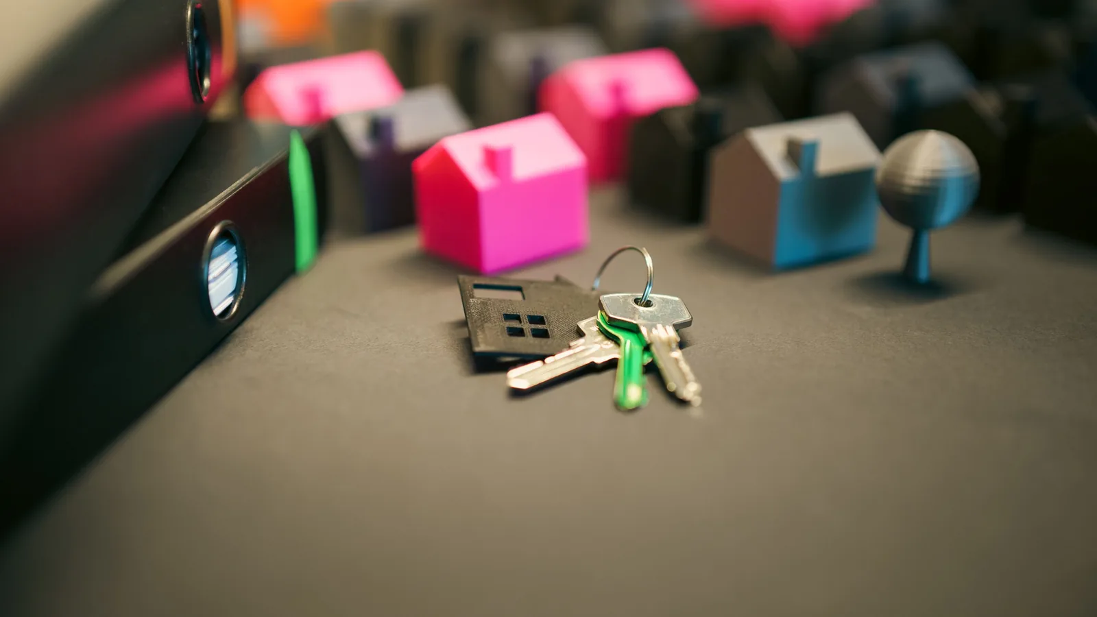 Miniature houses and keys arranged on a desk