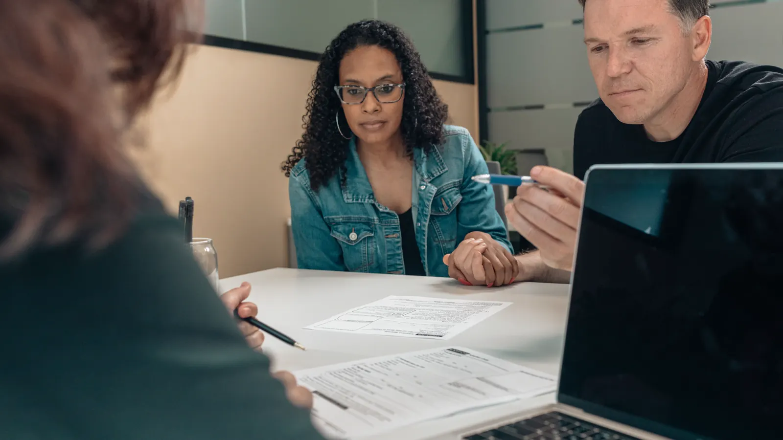 Couple reviewing documents with a professional at a table