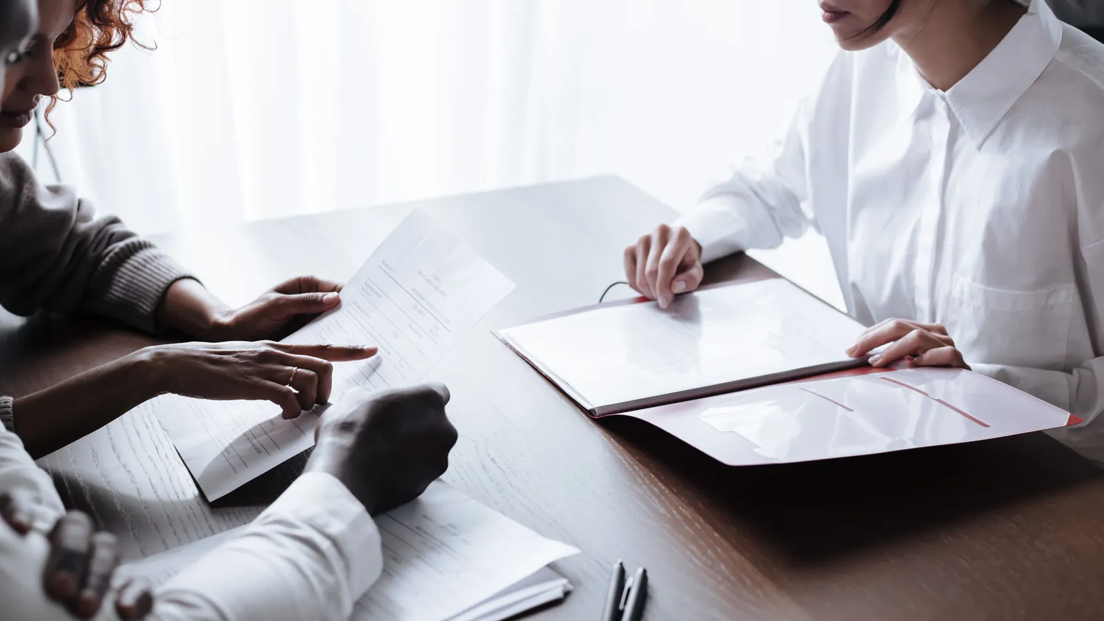Unmarried couple reviewing agreement and financial documents at a table